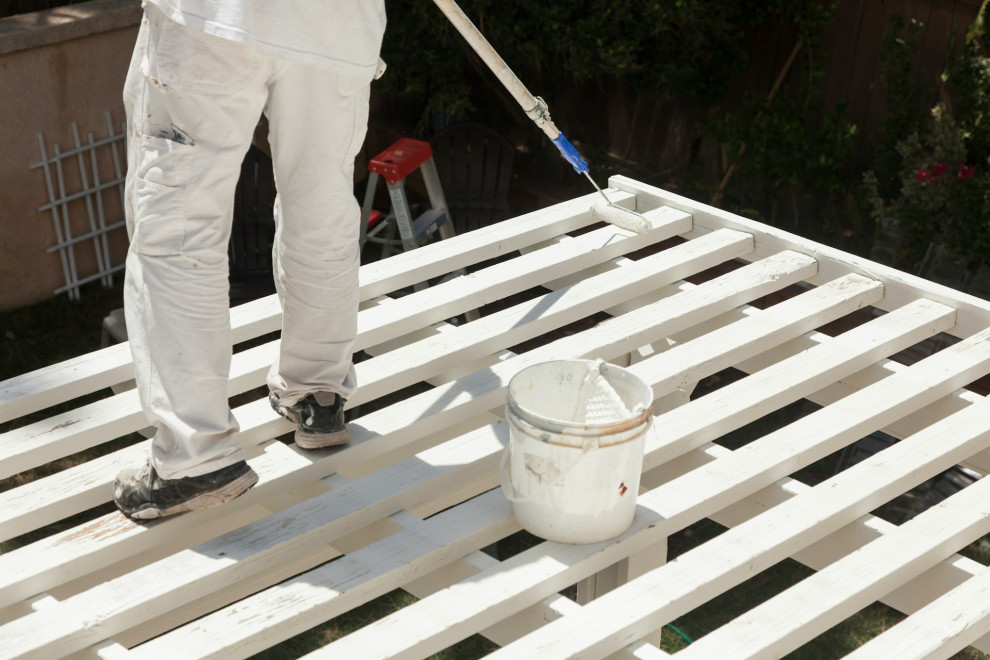 A man painting a deck