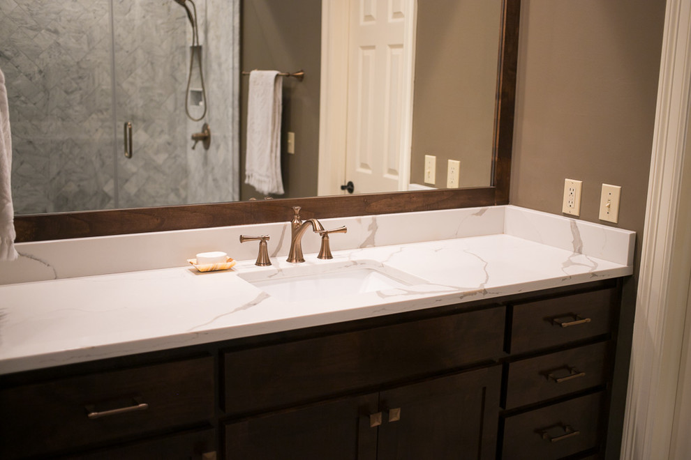 Inspiration for a large transitional master white tile and marble tile porcelain tile and gray floor corner shower remodel with shaker cabinets, dark wood cabinets, an undermount tub, a one-piece toilet, brown walls, an undermount sink, quartz countertops, a hinged shower door and white countertops