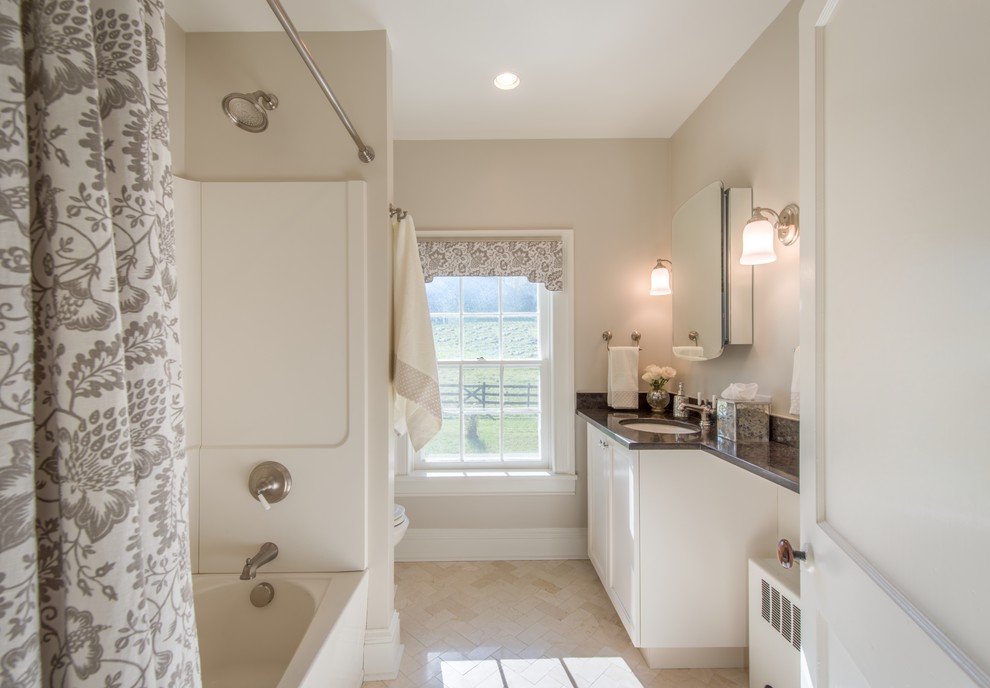 Design ideas for a mid-sized country kids bathroom in DC Metro with flat-panel cabinets, distressed cabinets, an alcove tub, a shower/bathtub combo, beige tile, white walls, marble floors, an undermount sink and solid surface benchtops.