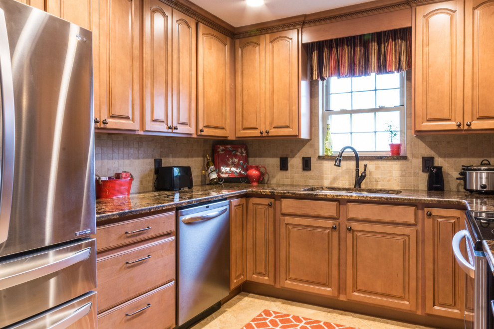 Eat-in kitchen - mid-sized u-shaped cement tile floor and beige floor eat-in kitchen idea with an undermount sink, raised-panel cabinets, medium tone wood cabinets, granite countertops, stainless steel appliances, no island and brown countertops