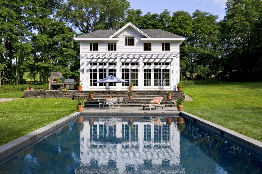 Design ideas for a traditional rectangular pool in New York with natural stone pavers.