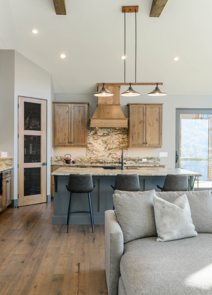 Transitional l-shaped medium tone wood floor and brown floor eat-in kitchen photo with an undermount sink, shaker cabinets, medium tone wood cabinets, multicolored backsplash, stone slab backsplash, stainless steel appliances, an island and multicolored countertops