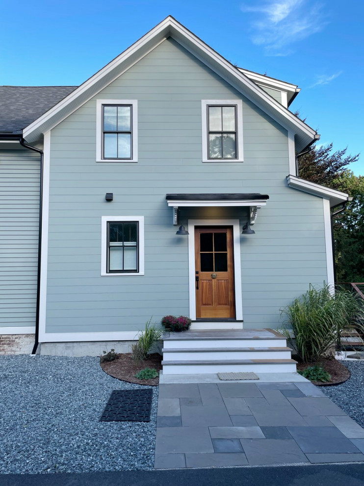 This is an example of a mid-sized scandinavian two-storey green house exterior in Providence with mixed siding, a gable roof, a shingle roof, a grey roof and clapboard siding.