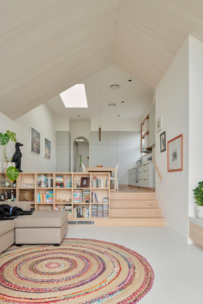 This is an example of a mid-sized contemporary open concept living room in Sydney with white walls, concrete floors, a freestanding tv, white floor and vaulted.