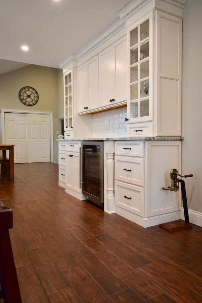 Enclosed kitchen - large transitional u-shaped dark wood floor and brown floor enclosed kitchen idea with a farmhouse sink, beaded inset cabinets, white cabinets, granite countertops, beige backsplash, ceramic backsplash, stainless steel appliances, an island and multicolored countertops