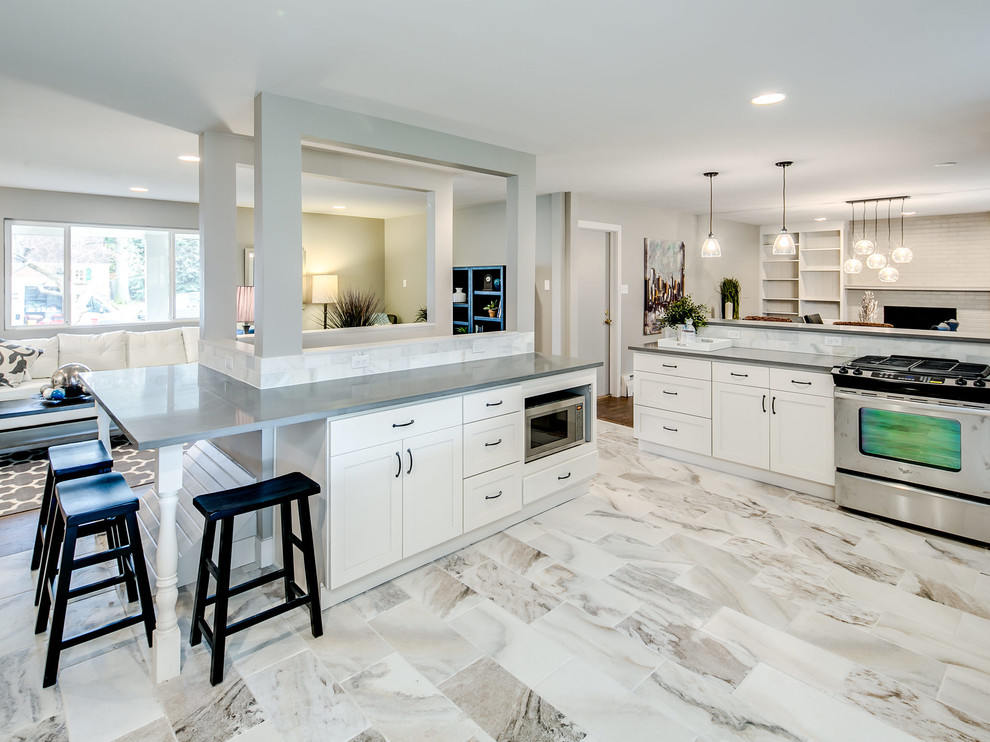 Large transitional l-shaped kitchen in Other with an undermount sink, shaker cabinets, white cabinets, white splashback, stainless steel appliances and a peninsula.