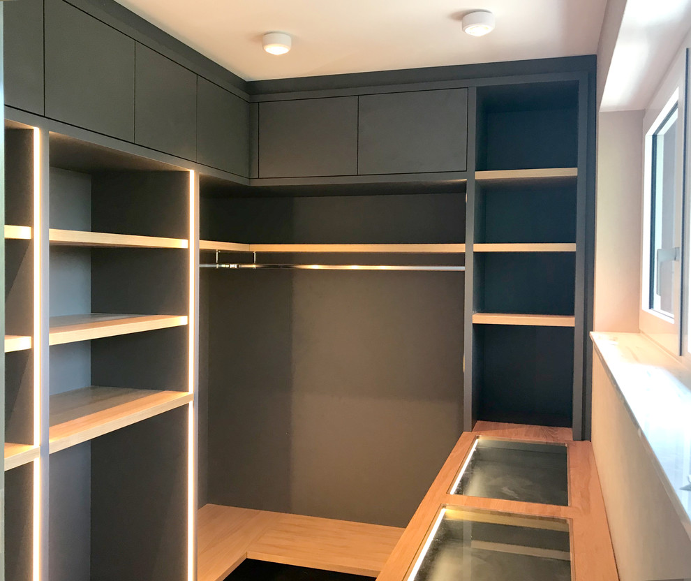 Begehbarer Kleiderschrank mit offenen Schränken, grauen Schränken, braunem Holzboden und braunem Boden in Dusseldorf