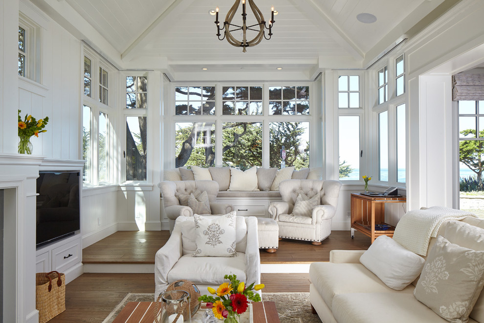 Photo of a mid-sized beach style open concept living room in San Francisco with white walls, medium hardwood floors, a built-in media wall, a standard fireplace and a stone fireplace surround.