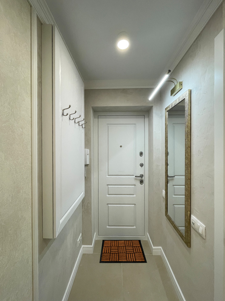 Idées déco pour un couloir classique de taille moyenne avec un mur beige, sol en stratifié, un sol beige et du papier peint.
