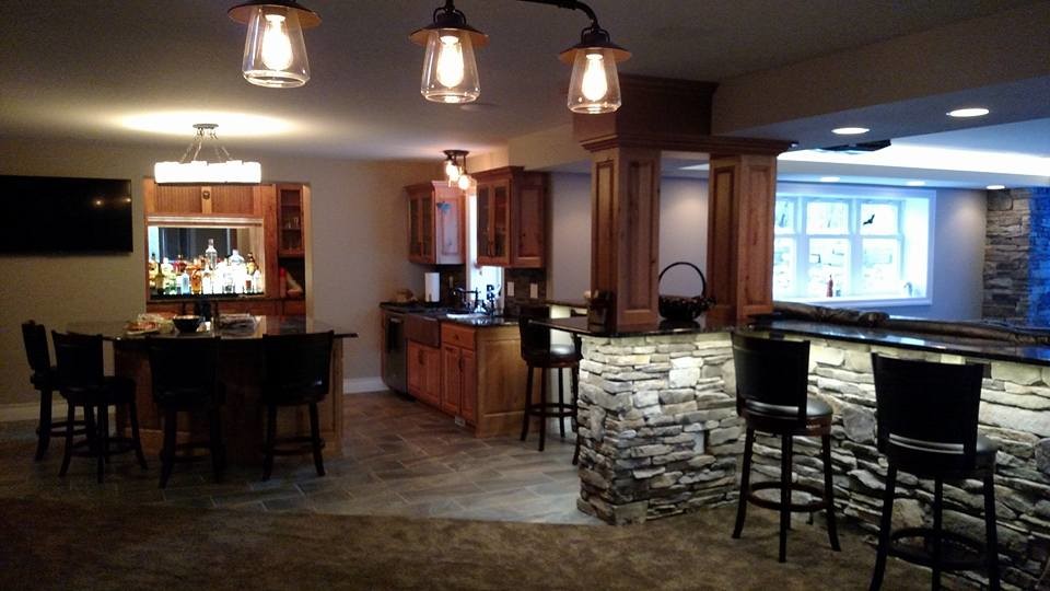 This is an example of a mid-sized country l-shaped wet bar in Other with stone tile splashback, an undermount sink, raised-panel cabinets, medium wood cabinets, granite benchtops and carpet.