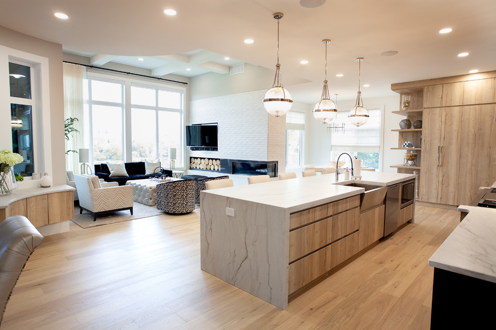 Inspiration for a mid-sized transitional single-wall open plan kitchen in Calgary with a farmhouse sink, glass-front cabinets, black cabinets, quartz benchtops, white splashback, subway tile splashback, stainless steel appliances, with island and beige benchtop.