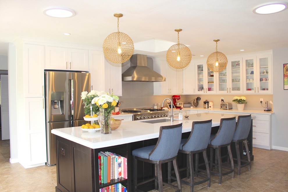 Large transitional l-shaped ceramic tile and beige floor open concept kitchen photo in Phoenix with an undermount sink, shaker cabinets, white cabinets, quartzite countertops, gray backsplash, stainless steel appliances and an island