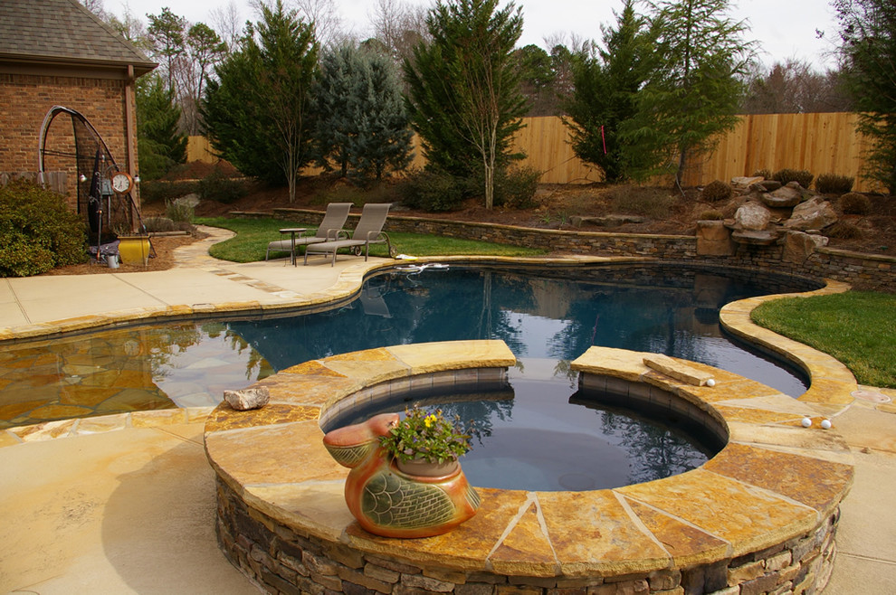 Inspiration for a mid-sized country backyard custom-shaped natural pool in Charlotte with a water feature and decomposed granite.
