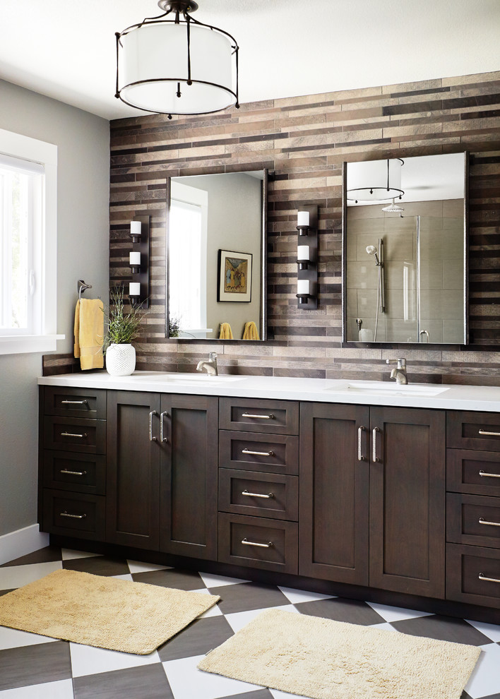 Inspiration for a mid-sized transitional master bathroom in San Francisco with an undermount sink, shaker cabinets, dark wood cabinets, brown tile, grey walls, solid surface benchtops, stone tile, porcelain floors and multi-coloured floor.