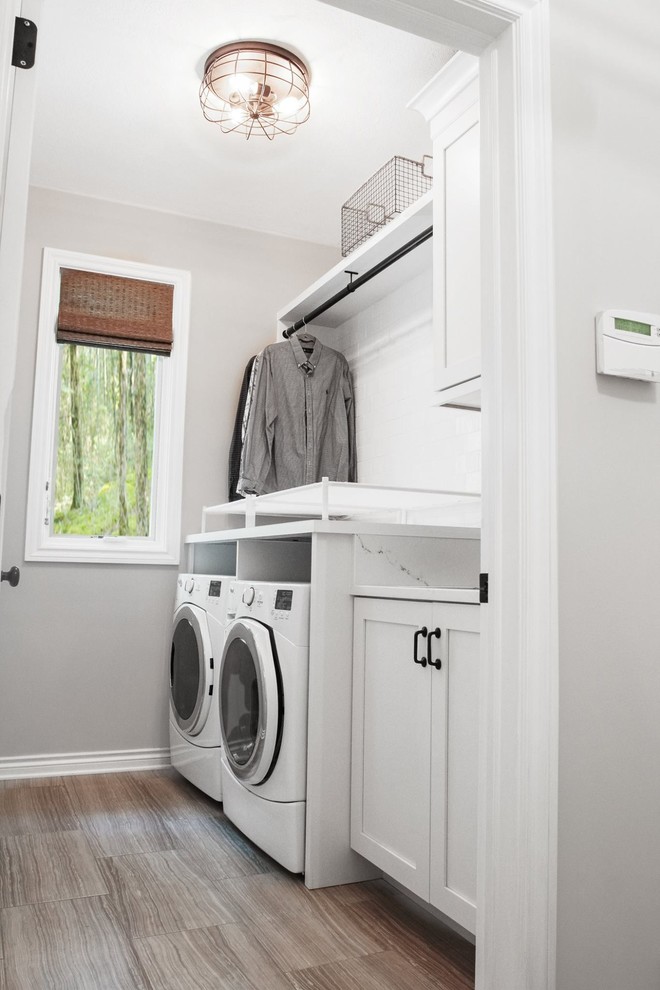 Inspiration for a small transitional single-wall dedicated laundry room in Other with a single-bowl sink, shaker cabinets, white cabinets, quartz benchtops, grey walls, porcelain floors and a side-by-side washer and dryer.