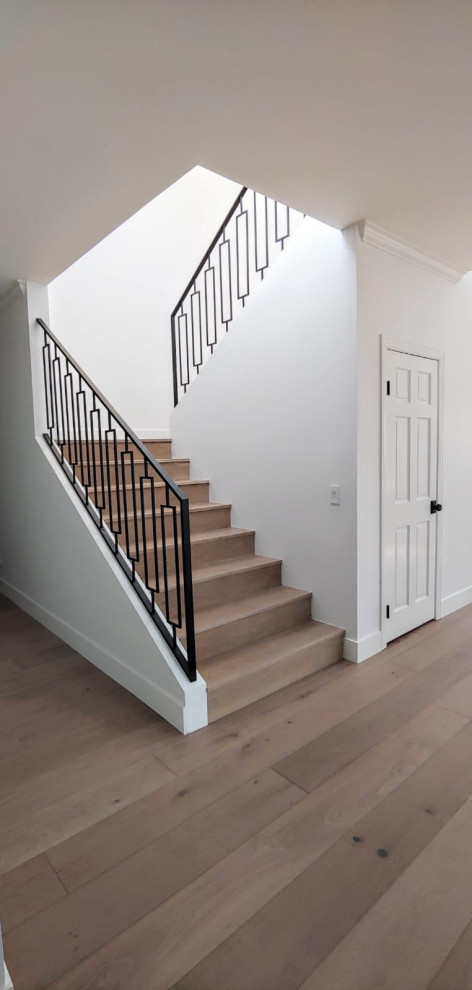 Imagen de escalera en L minimalista de tamaño medio con escalones de madera, contrahuellas de metal y barandilla de metal