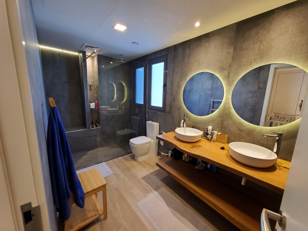 Aménagement d'une salle de bain principale moderne de taille moyenne avec un carrelage gris, un sol en carrelage imitation parquet, un plan vasque, un plan de toilette en bois, aucune cabine, meuble double vasque et meuble-lavabo suspendu.