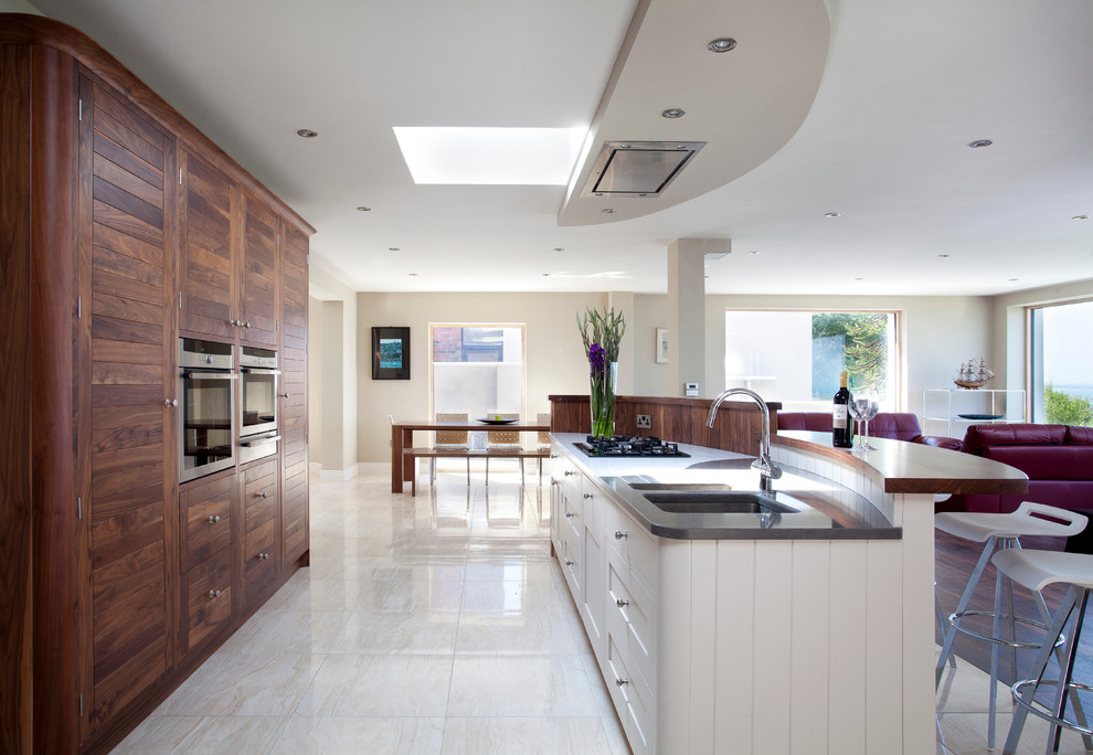 Design ideas for a contemporary open plan kitchen in Dublin with an undermount sink, shaker cabinets, white cabinets, panelled appliances and with island.