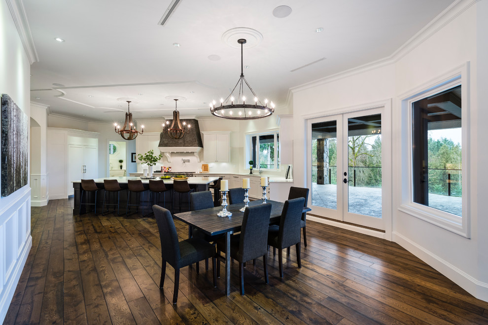 Example of a huge mountain style u-shaped medium tone wood floor and brown floor great room design in Vancouver with an undermount sink, shaker cabinets, white cabinets, solid surface countertops, white backsplash, stone slab backsplash, stainless steel appliances, an island and white countertops