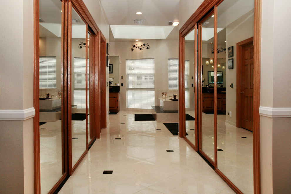 Large modern gender-neutral walk-in wardrobe in Los Angeles with open cabinets, medium wood cabinets and ceramic floors.
