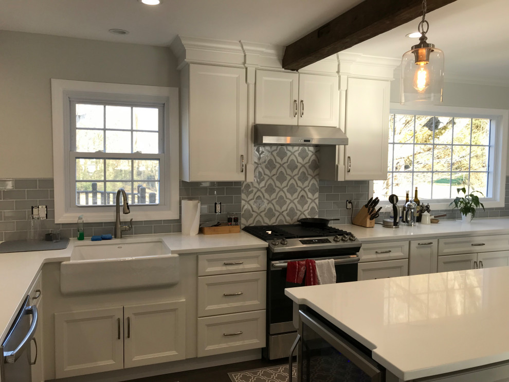 Example of a large transitional u-shaped ceramic tile and gray floor eat-in kitchen design with a farmhouse sink, recessed-panel cabinets, white cabinets, quartz countertops, gray backsplash, subway tile backsplash, stainless steel appliances, an island and white countertops