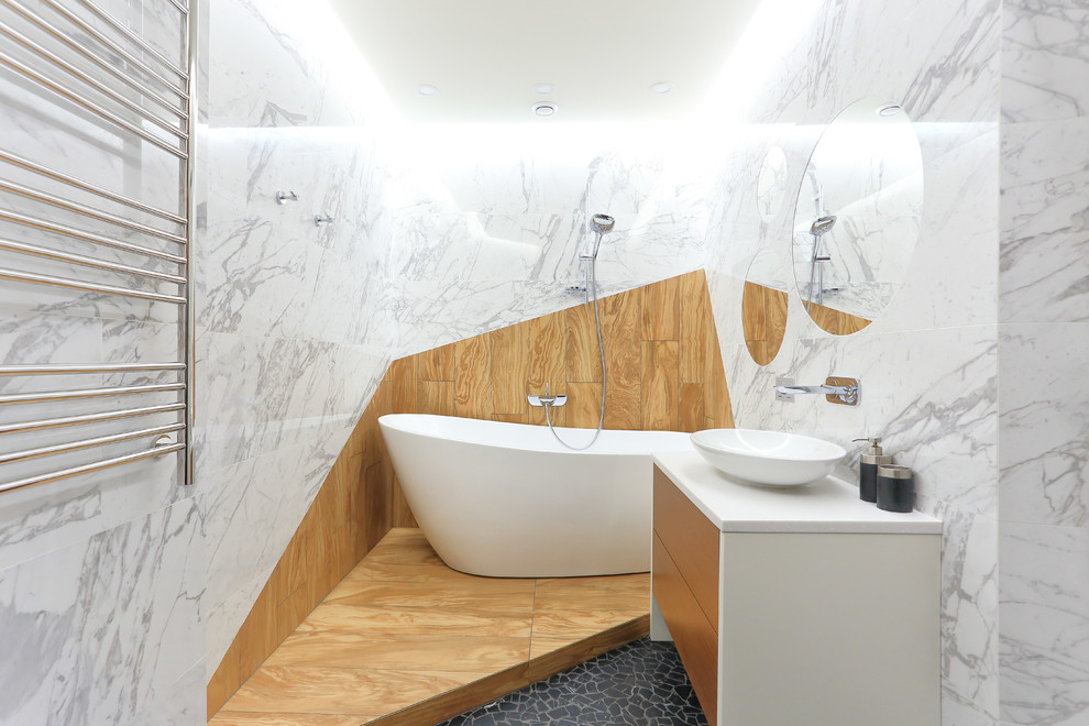 Пример оригинального дизайна: главная ванная комната в современном стиле с отдельно стоящей ванной, инсталляцией, керамогранитной плиткой, полом из керамогранита, накладной раковиной и столешницей из искусственного камня