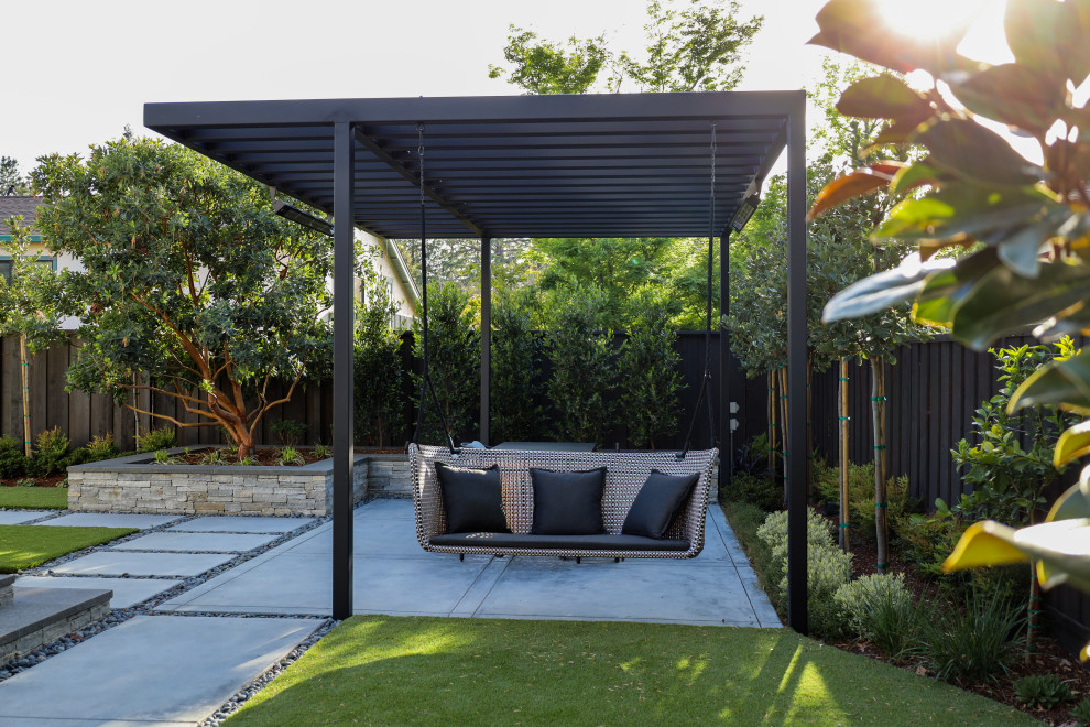 Foto de patio minimalista de tamaño medio en patio trasero con jardín de macetas, adoquines de hormigón y pérgola