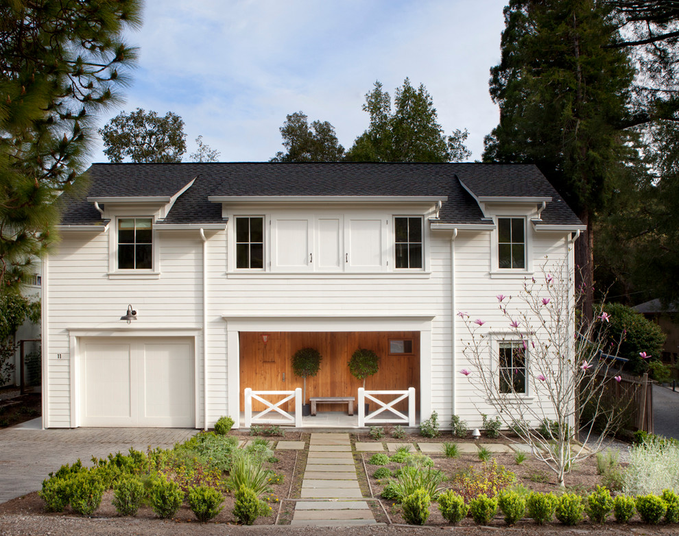 Design ideas for a country two-storey white exterior in Other with wood siding.