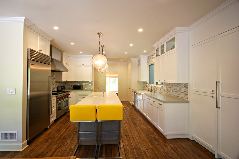 Photo of a large transitional u-shaped eat-in kitchen in Los Angeles with a farmhouse sink, shaker cabinets, white cabinets, multi-coloured splashback, matchstick tile splashback, stainless steel appliances, medium hardwood floors, with island, quartz benchtops and beige floor.