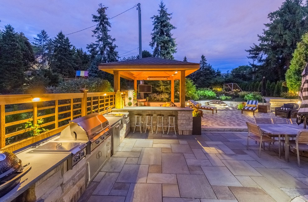 Inspiration for a large traditional backyard patio in Milwaukee with an outdoor kitchen, a gazebo/cabana and natural stone pavers.