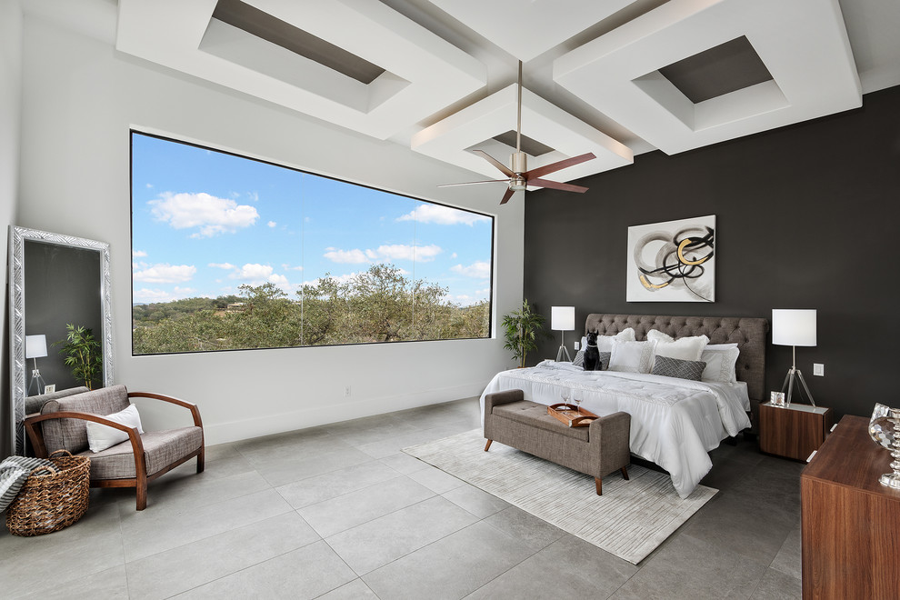 This is an example of a contemporary master bedroom in Austin with black walls, no fireplace and grey floor.