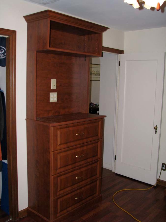 This is an example of a large traditional gender-neutral walk-in wardrobe in New York with medium wood cabinets.