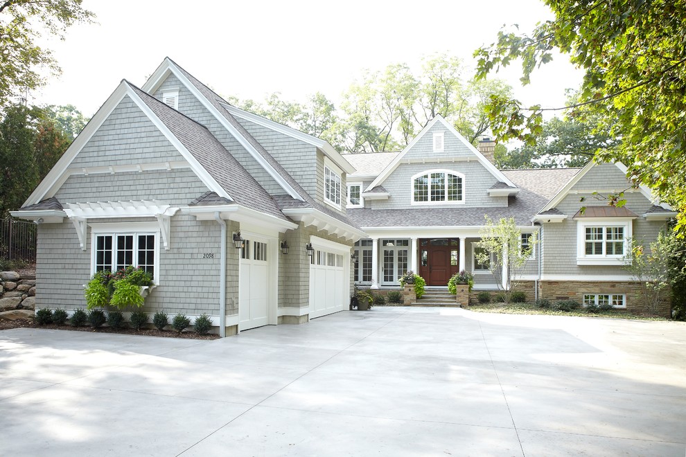 Large traditional two-storey grey house exterior in Grand Rapids with wood siding, a gable roof and a shingle roof.