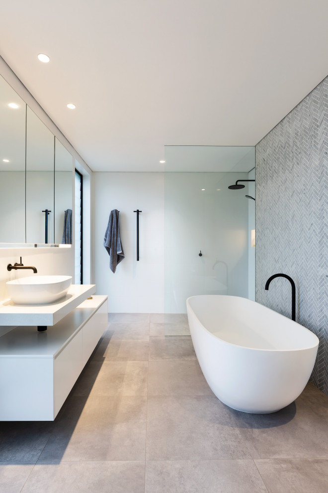 Modernes Badezimmer mit flächenbündigen Schrankfronten, weißen Schränken, freistehender Badewanne, grauen Fliesen, Mosaikfliesen, weißer Wandfarbe, Aufsatzwaschbecken, grauem Boden, weißer Waschtischplatte, Einzelwaschbecken und schwebendem Waschtisch in Sydney