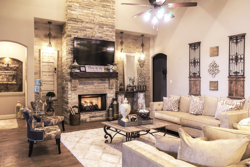 Inspiration for a large farmhouse open plan living room in Dallas with beige walls, a standard fireplace, a stone fireplace surround, a wall mounted tv, exposed beams and brick walls.