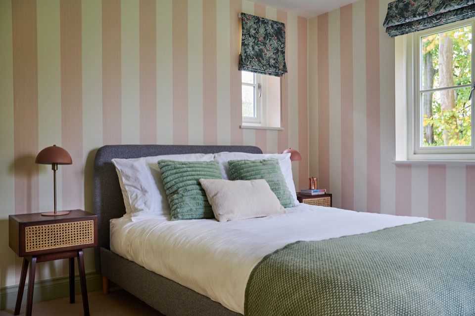 Immagine di una piccola camera degli ospiti nordica con pareti rosa, moquette, nessun camino, pavimento beige e carta da parati
