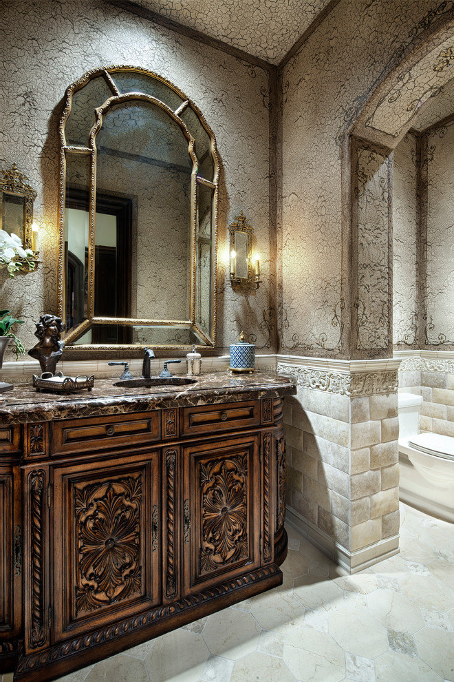 Design ideas for a traditional bathroom in Houston with an undermount sink, dark wood cabinets and beige tile.