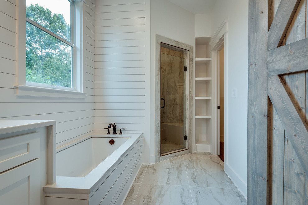 Design ideas for a large country master wet room bathroom in Nashville with shaker cabinets, white cabinets, a drop-in tub, a one-piece toilet, beige tile, porcelain tile, white walls, porcelain floors, a drop-in sink, engineered quartz benchtops, beige floor, a hinged shower door and white benchtops.