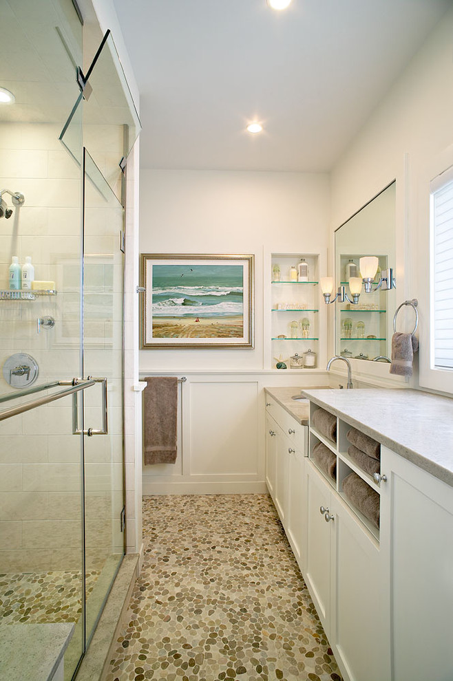 Inspiration for a beach style bathroom in New York with an undermount sink, shaker cabinets, white cabinets, an alcove shower, white tile and pebble tile floors.