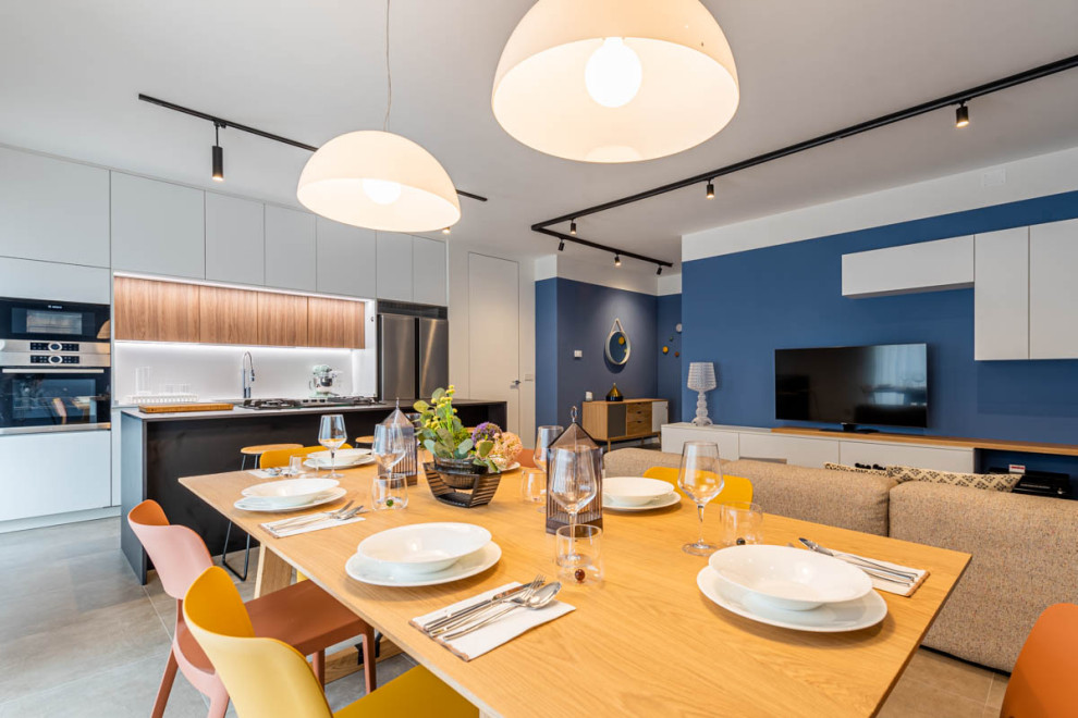Photo of a large contemporary galley open plan kitchen in Other with a submerged sink, flat-panel cabinets, white cabinets, engineered stone countertops, white splashback, stone slab splashback, stainless steel appliances, porcelain flooring, an island, beige floors and black worktops.