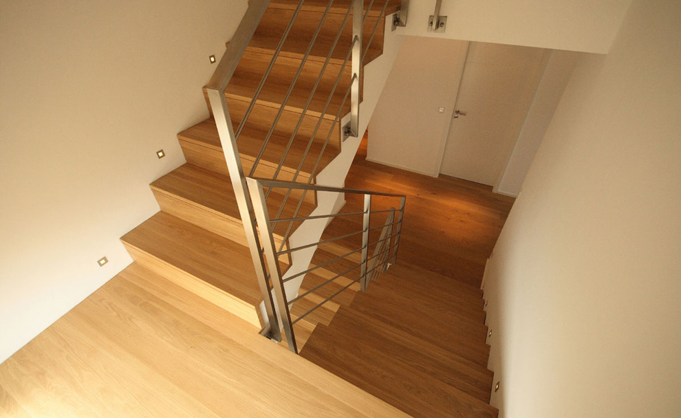 Exempel på en mellanstor u-trappa i trä, med sättsteg i trä och räcke i metall