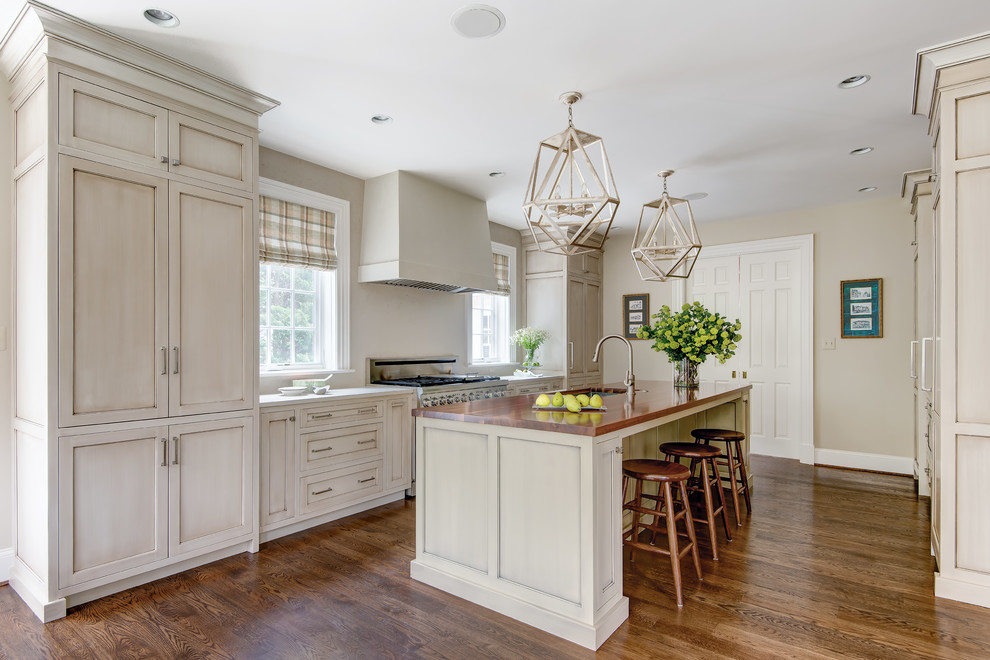 Traditional galley kitchen in DC Metro with an undermount sink, shaker cabinets, light wood cabinets, stainless steel appliances, dark hardwood floors, with island, brown floor and white benchtop.