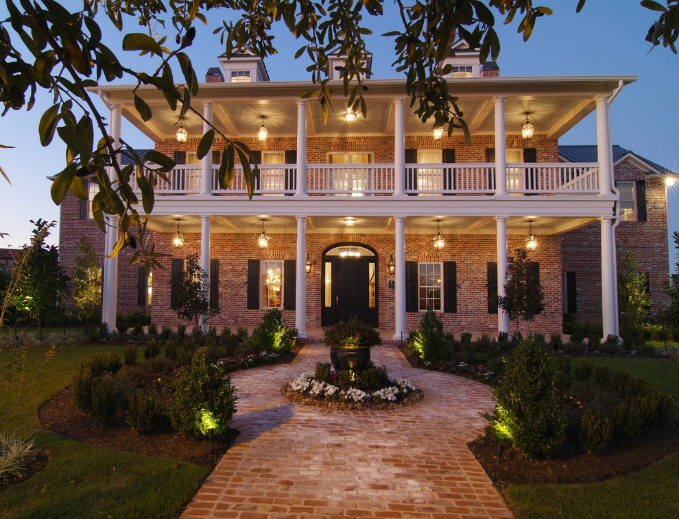 This is an example of a large traditional three-storey brick red exterior in Houston.