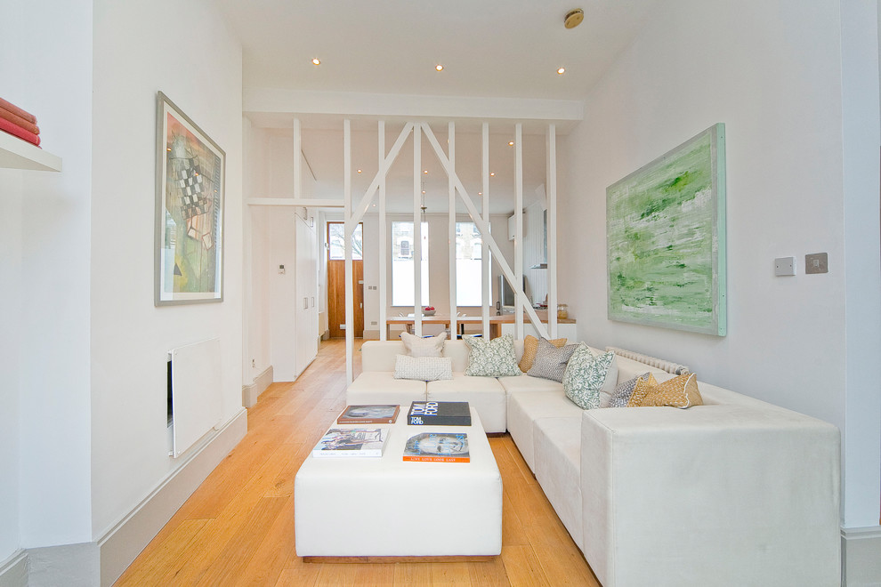 Photo of a contemporary formal enclosed living room in London with white walls, medium hardwood floors, a ribbon fireplace, a plaster fireplace surround, no tv and orange floor.