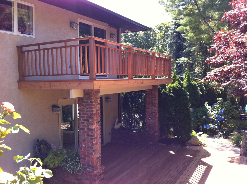Photo of a mid-sized eclectic backyard deck in New York with a roof extension.
