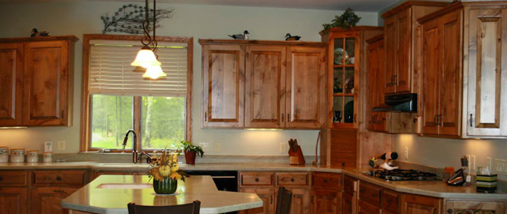 Kitchen - kitchen idea with medium tone wood cabinets, beige backsplash, black appliances and an island