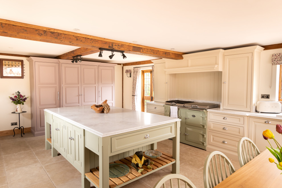 Design ideas for an expansive traditional galley open plan kitchen in Essex with a double-bowl sink, raised-panel cabinets, green cabinets, quartzite benchtops, coloured appliances, porcelain floors, with island, beige floor, white benchtop and exposed beam.