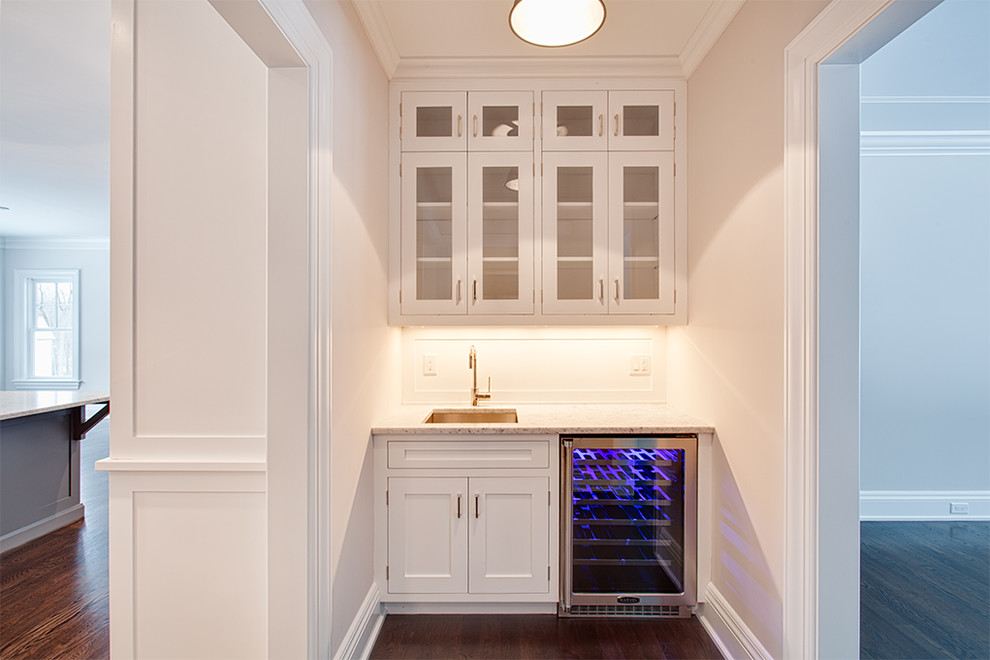 Example of a large transitional u-shaped dark wood floor and brown floor eat-in kitchen design with an undermount sink, shaker cabinets, white cabinets, white backsplash, stainless steel appliances and an island