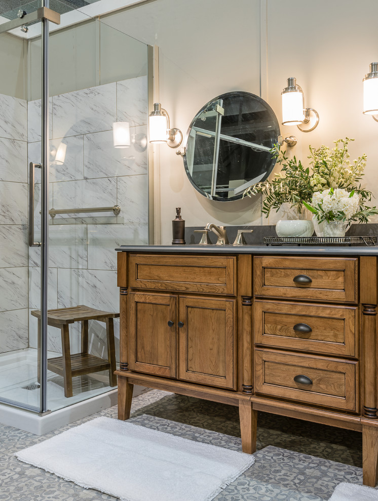 Mid-sized country master bathroom in Providence with shaker cabinets, medium wood cabinets, a corner shower, a two-piece toilet, white tile, ceramic tile, grey walls, a wall-mount sink, engineered quartz benchtops, grey floor and a hinged shower door.