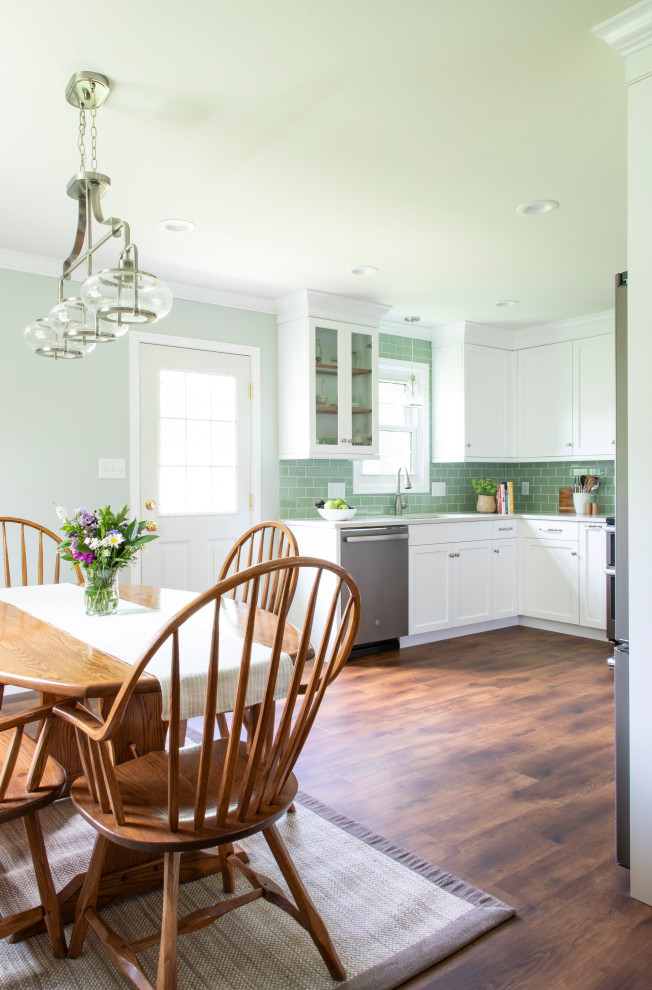Example of a transitional vinyl floor kitchen design with an undermount sink, shaker cabinets, white cabinets, quartz countertops, green backsplash, glass tile backsplash, stainless steel appliances, no island and white countertops